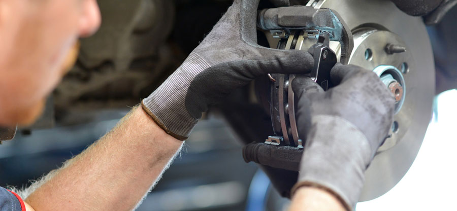 Chandler & Sons Technician installing brake pads