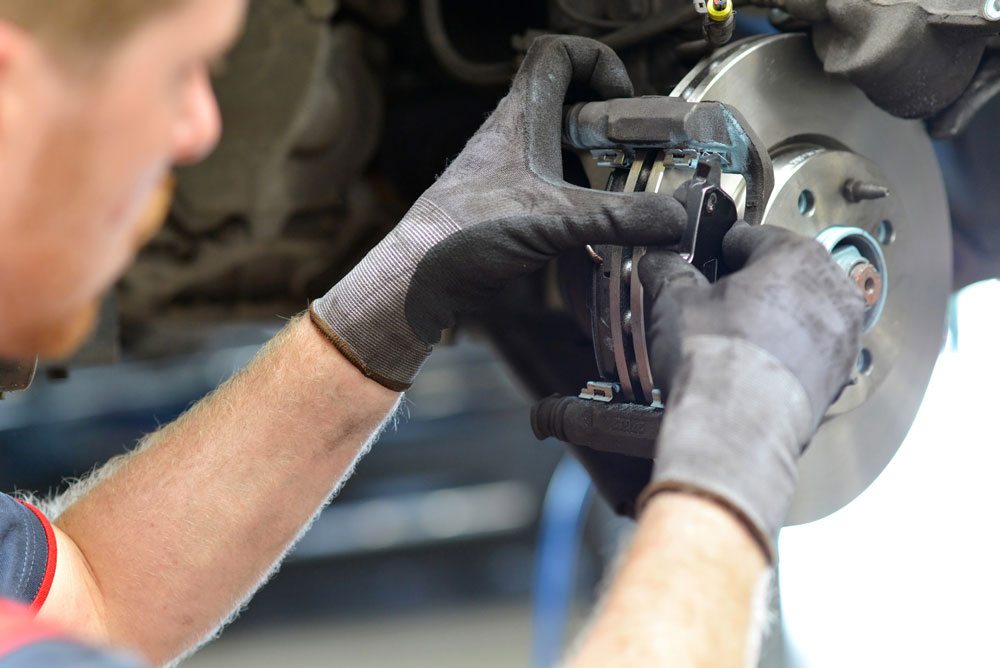 Chandler & Sons Technician installing brake pads