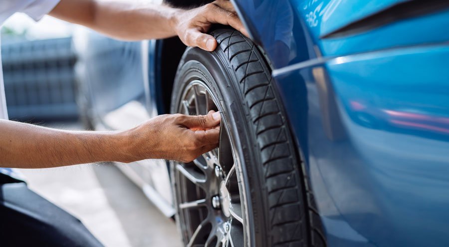 Chandler & Sons Automotive Technician working on a Tire